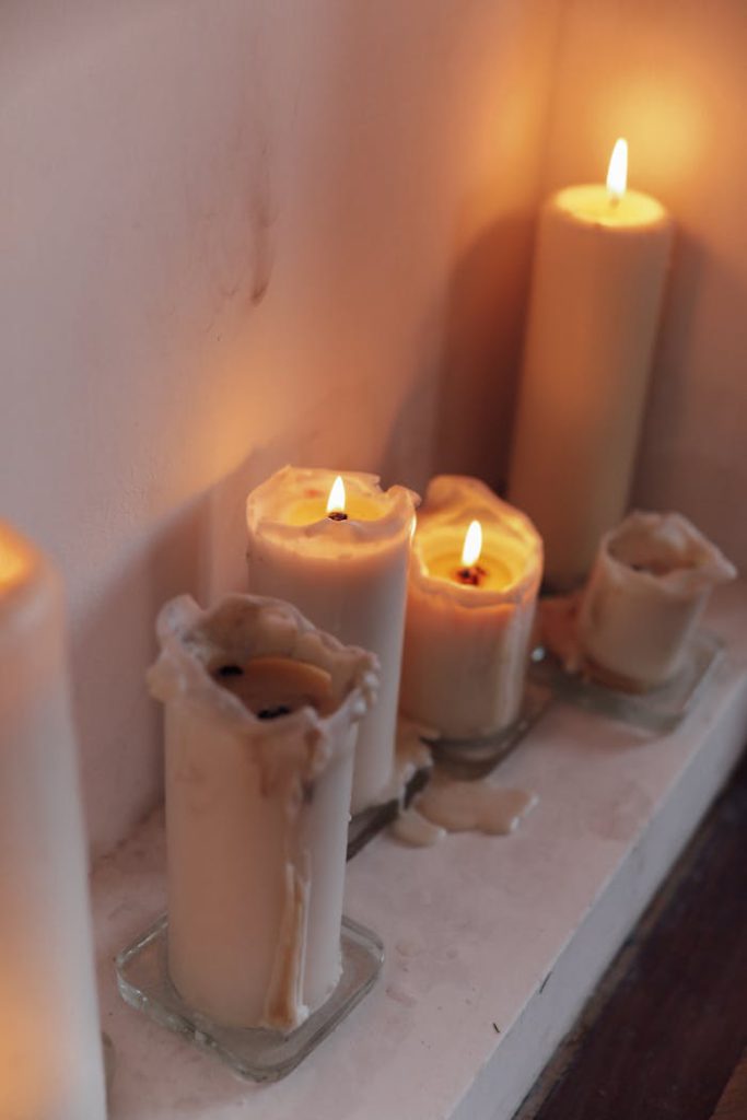 A close-up of wax-dripped candles casting a warm glow, perfect for creating a cozy atmosphere.