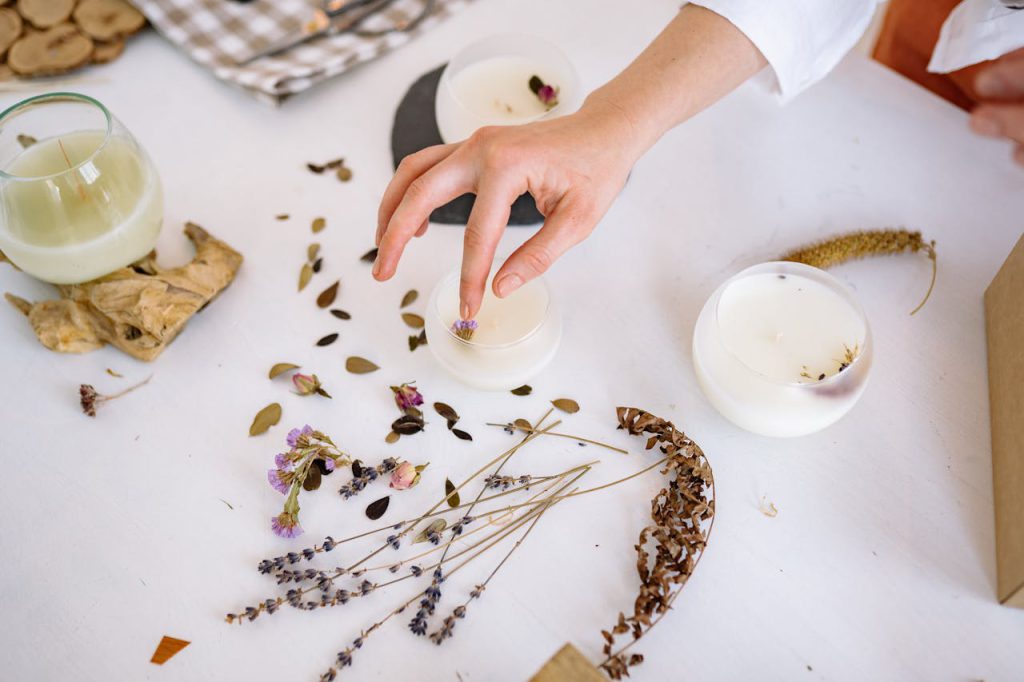 Creating handmade candles with dried flowers and leaves for unique decorations.